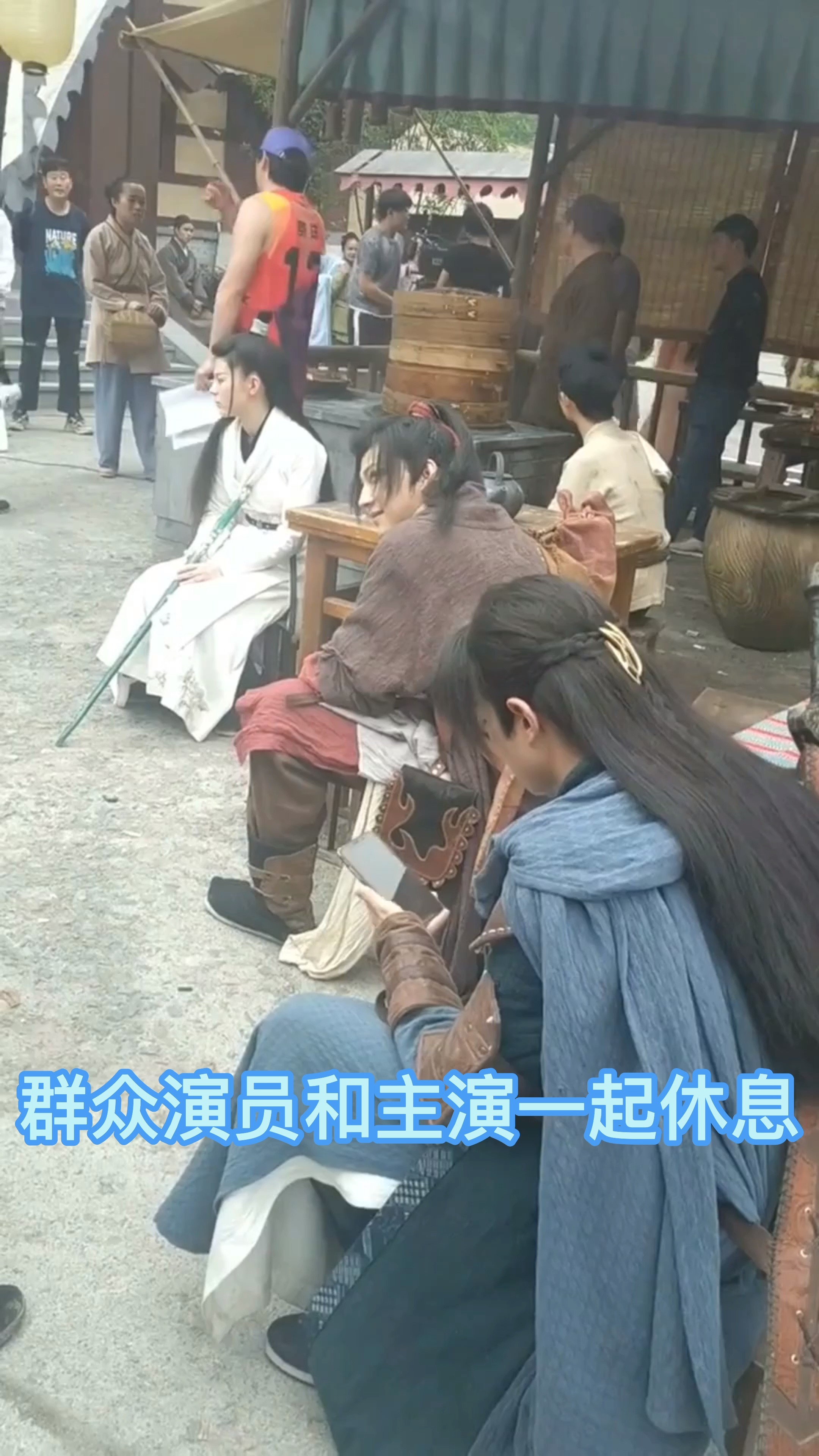 古裝劇拍戲現場,群眾演員和主演一起休息