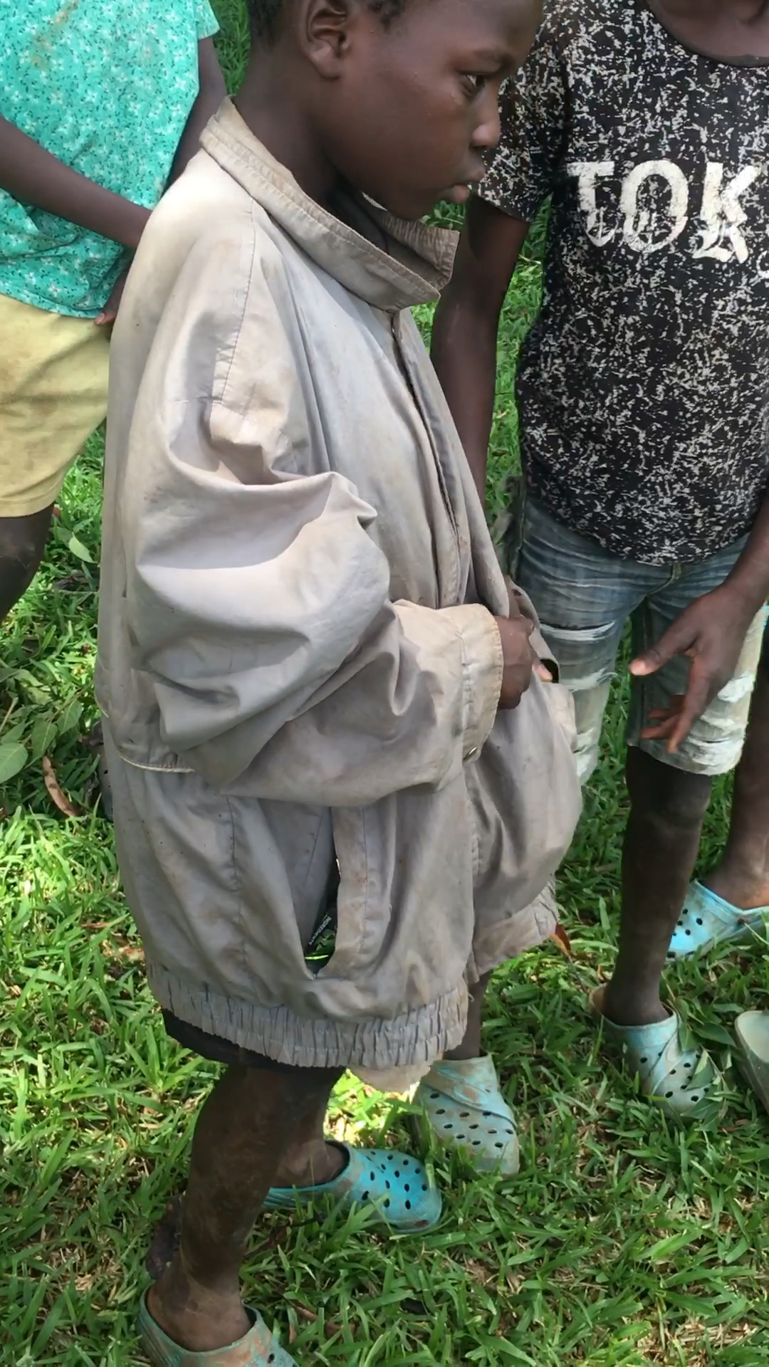 这孩子没衣服穿,穿着爸爸的衣服.很不合身.