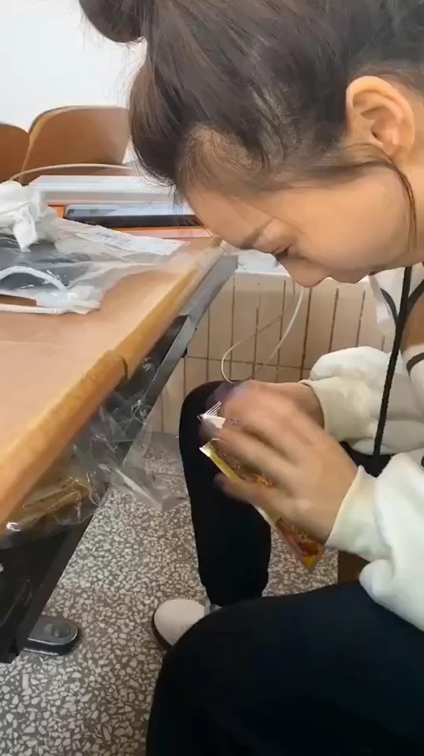 某校女大学生上课偷吃辣条