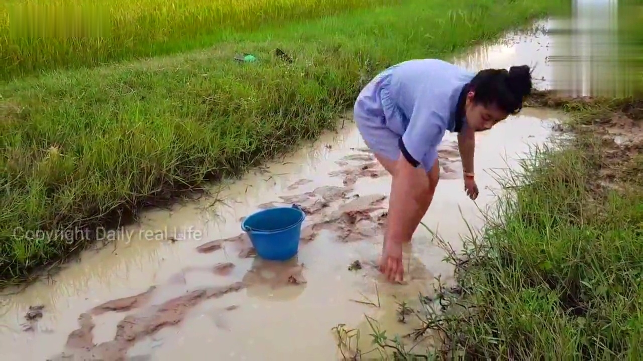 闲来无事,农村小美女背着锄头和水桶到郊区逮鱼